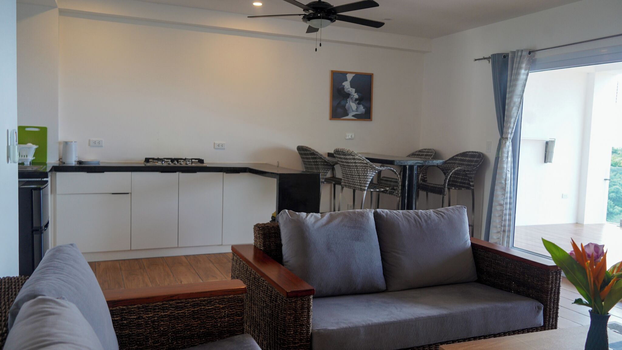 A modern living room with a sofa, a coffee table, and a dining area with chairs and a table.