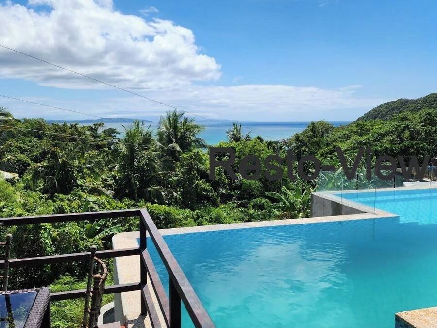 Una piscina con vistas a un paisaje tropical y montañas.