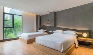Een moderne slaapkamer met twee bedden, een groot raam en uitzicht op groen.