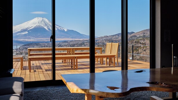 A room with large windows offering a view of a mountain. Inside, there is a wooden table and benches. - Sauna BBQ with a spectacular view of Mt. Fuji｜Max 20 people｜The No. 10 Mt. (minamitsuru-gun yamanaka-ko hirano)