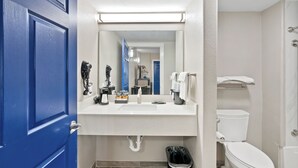 A bathroom with a blue door, white sink, and toilet. - 2nd level pool front • Kitchen • Walk to Beach (Rockport)