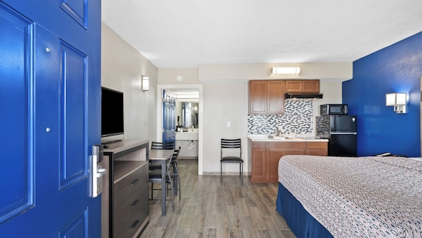 A compact hotel room with a kitchenette, a bed, a desk, and a television. - Across from festival grounds & blue wave beach ADA (Rockport)