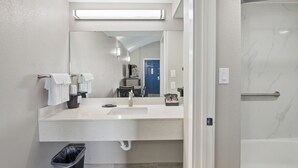 A modern bathroom with a large mirror, a sink, and a shower. - Waterview Penthouse, pool, stroll to marina, beach (Rockport)