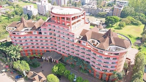 A multi-story hotel with a curved facade, balconies, and a central courtyard.