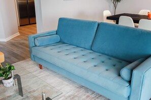 Ein hellblaues Sofa mit einer gepolsterten Optik in einem modernen Wohnzimmer.