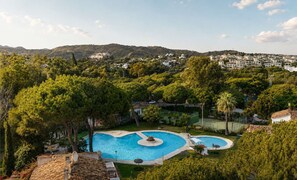 A residential area with a swimming pool surrounded by trees and houses. - Los Arcos | Charming Patio Pool Townhouse (Marbella)