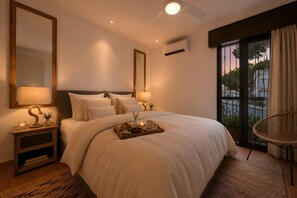 Een hotelkamer met een groot bed, bedlampen, een dienblad met ontbijtartikelen, een stoel en uitzicht op de omgeving.