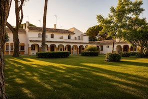 A courtyard with a building featuring arches and a tiled roof. - Los Arcos | Charming Patio Pool Townhouse (Marbella)