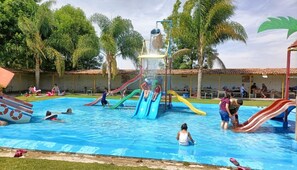 Una piscina con varias toboganes y una fuente de agua.