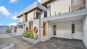 A modern building with a stone facade, wooden accents, and a courtyard with potted plants. - deTasia Villa by Kozystay - Jimbaran (Jimbaran)