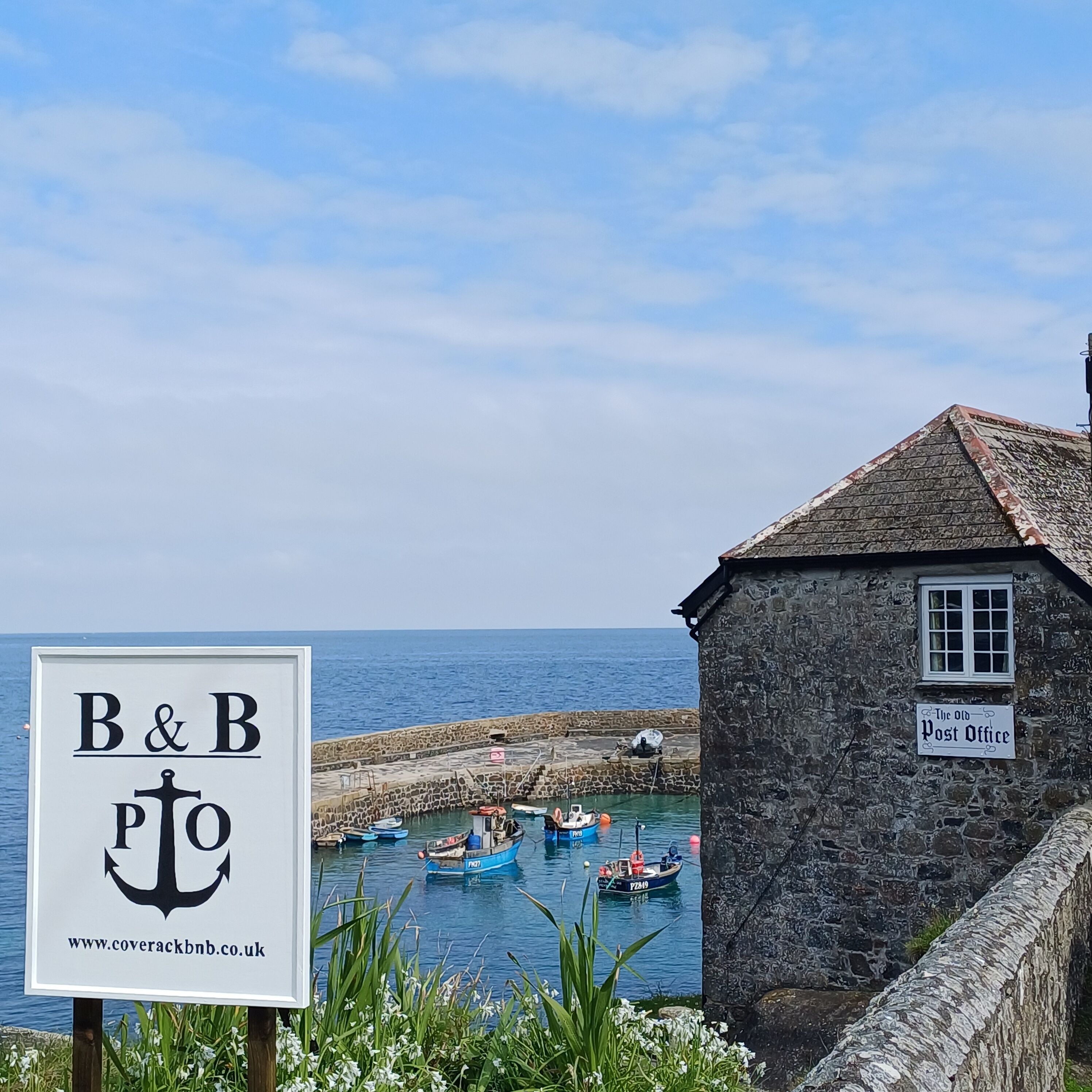 A coastal scene with a sign for 'B&B' and a stone building labeled 'The Old Post Office.'