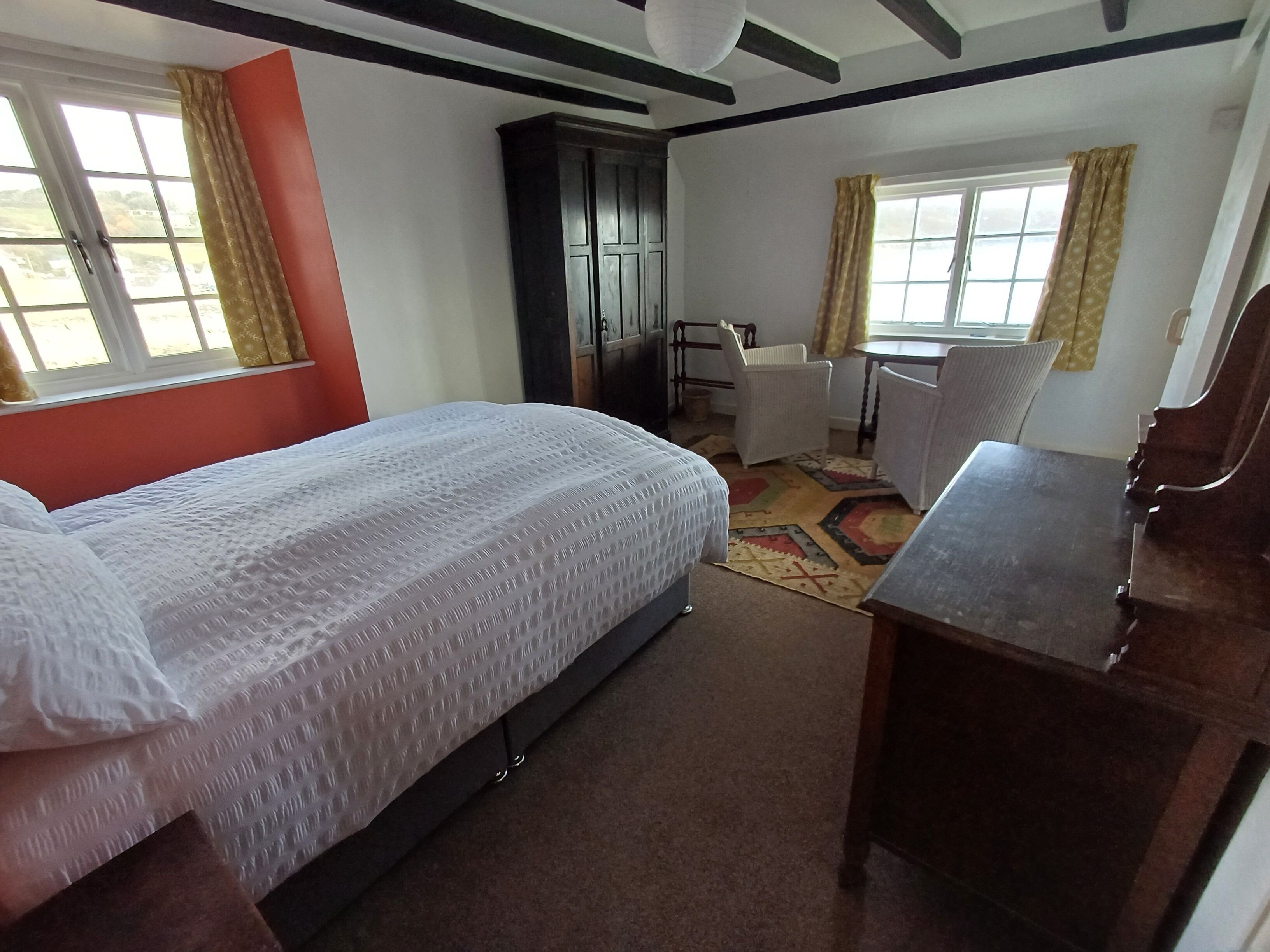 Un dormitorio con cama, escritorio, silla y armario.