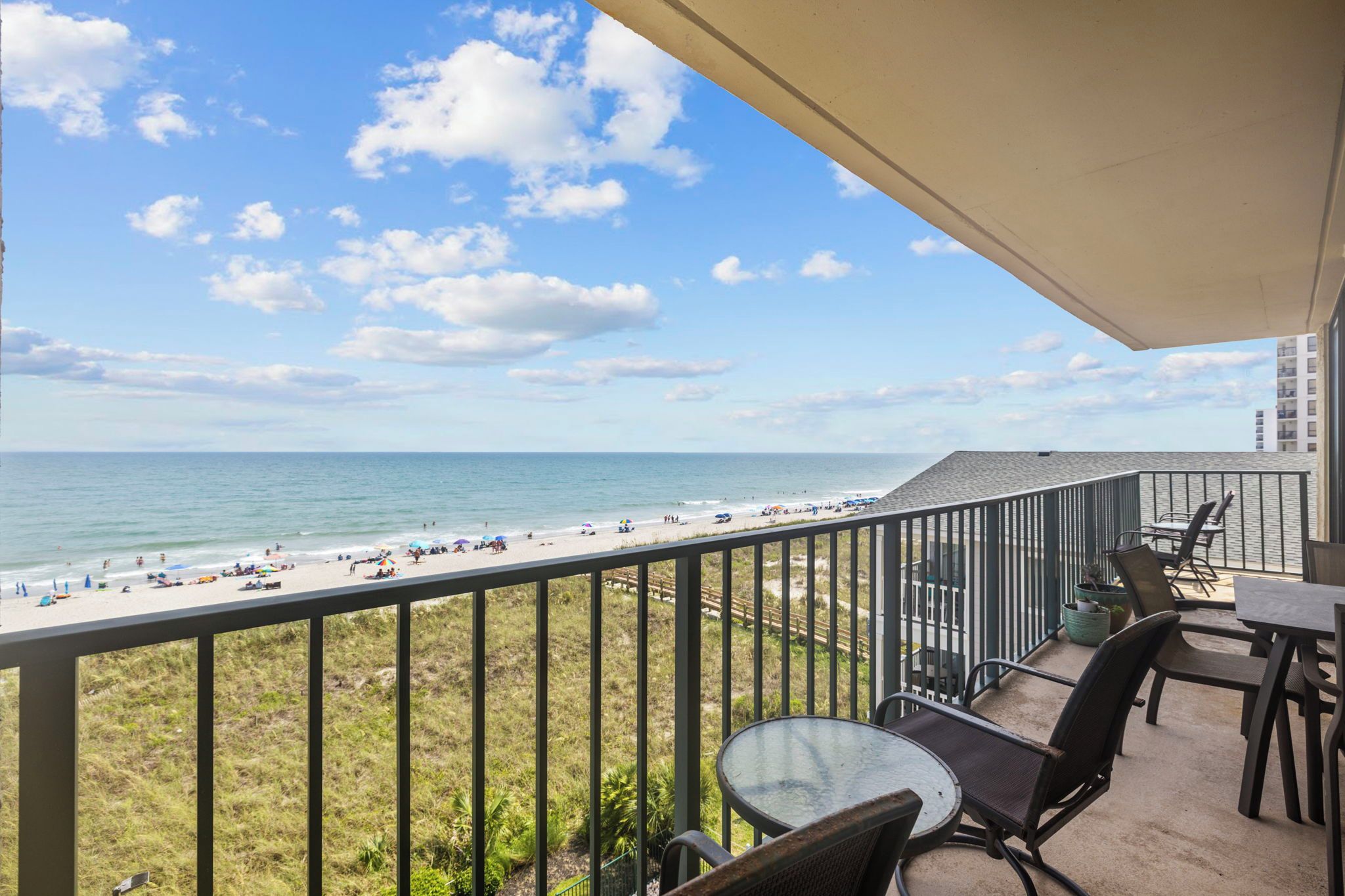 Un balcon avec vue sur une plage et l’océan.