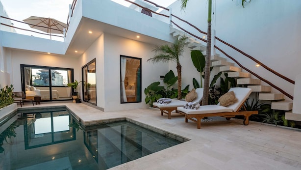 A modern house with a swimming pool, a lounge area with a sun lounger, and a staircase. - Villa Lu'um (Canggu)