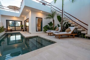 A modern house with a swimming pool, a lounge area with a sun lounger, and a staircase. - Villa Lu'um (Canggu)