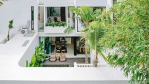 A modern two-story house with a flat roof, large windows, and a balcony with plants. - Casa Ipanema (Kerobokan)
