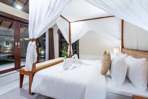 Quarto com cama de dossel, um banco e arranjo de toalhas em formato de cisne.