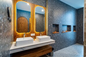 A modern bathroom with two sinks, wooden vanity, and a large mirror.