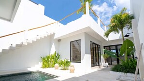 Una casa moderna con piscina, escalera y un amplio ventanal.