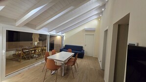 Un loft moderne comprenant un coin repas, un canapé et un téléviseur.