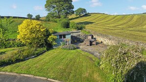 A rural setting with a stone house, a large tree, and rolling green hills. - 5 bedroom accommodation in Halfpenny, near Kendal (Halfpenny, near Kendal)