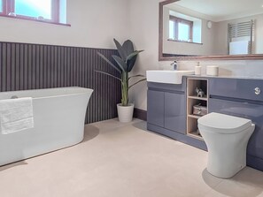 Un baño moderno con bañera, lavabo e inodoro.