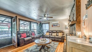 Ein gemütliches Wohnzimmer mit Ledersofas, einem Holztisch und einem Weihnachtsbaum.
