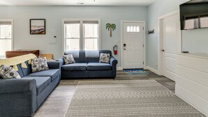 A living room with a blue sofa, a patterned rug, and a ceiling fan. - Walk to Beach & Explore Boardwalk: Wildwood Escape (Wildwood)