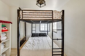 A bunk bed room with a window, a wardrobe, and a shelf with folded clothes. - Fullerton Home Base: Easy Access to Dtwn + CSUF! (Fullerton)