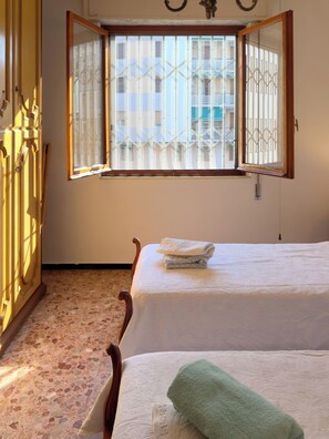 A room with two beds, a wardrobe, and a window with bars. - Casa Francy - Taggia (Taggia)
