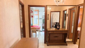 A hallway with a wooden table and a cabinet with decorative items. - Casa Francy - Taggia (Taggia)