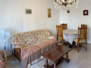A living room with a sofa, a table, chairs, a fan, and a chandelier. - Casa Francy - Taggia (Taggia)