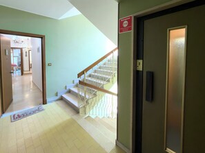 A hotel hallway with a staircase, a reception area, and a door with an emergency sign. - Casa Francy - Taggia (Taggia)