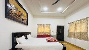 Une chambre à coucher comprenant un lit, une table de chevet, une armoire et un ventilateur de plafond.