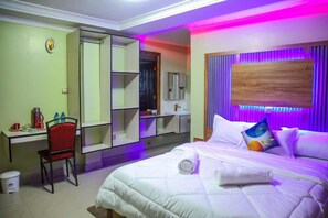 A hotel room with a bed, a desk, a chair, and a mirror. - Watervibe Hotel Ruiru (Ruiru)