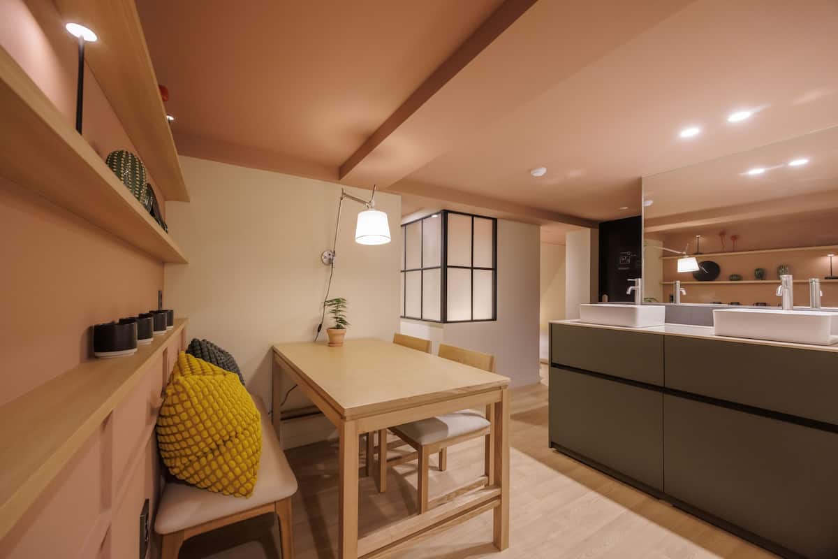 Una cocina moderna con una mesa de comedor de madera, un banco y una isla integrada con fregadero.