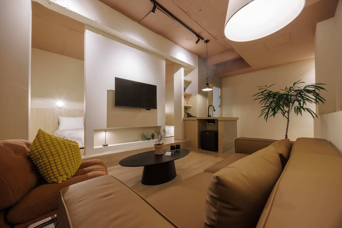 Una sala de estar moderna con un sofá, una mesa de centro y un televisor montado en la pared.