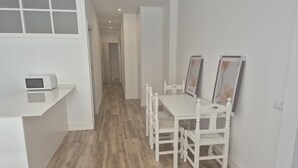Eine moderne Küche mit Mikrowelle, weißen Schränken und Holzboden.