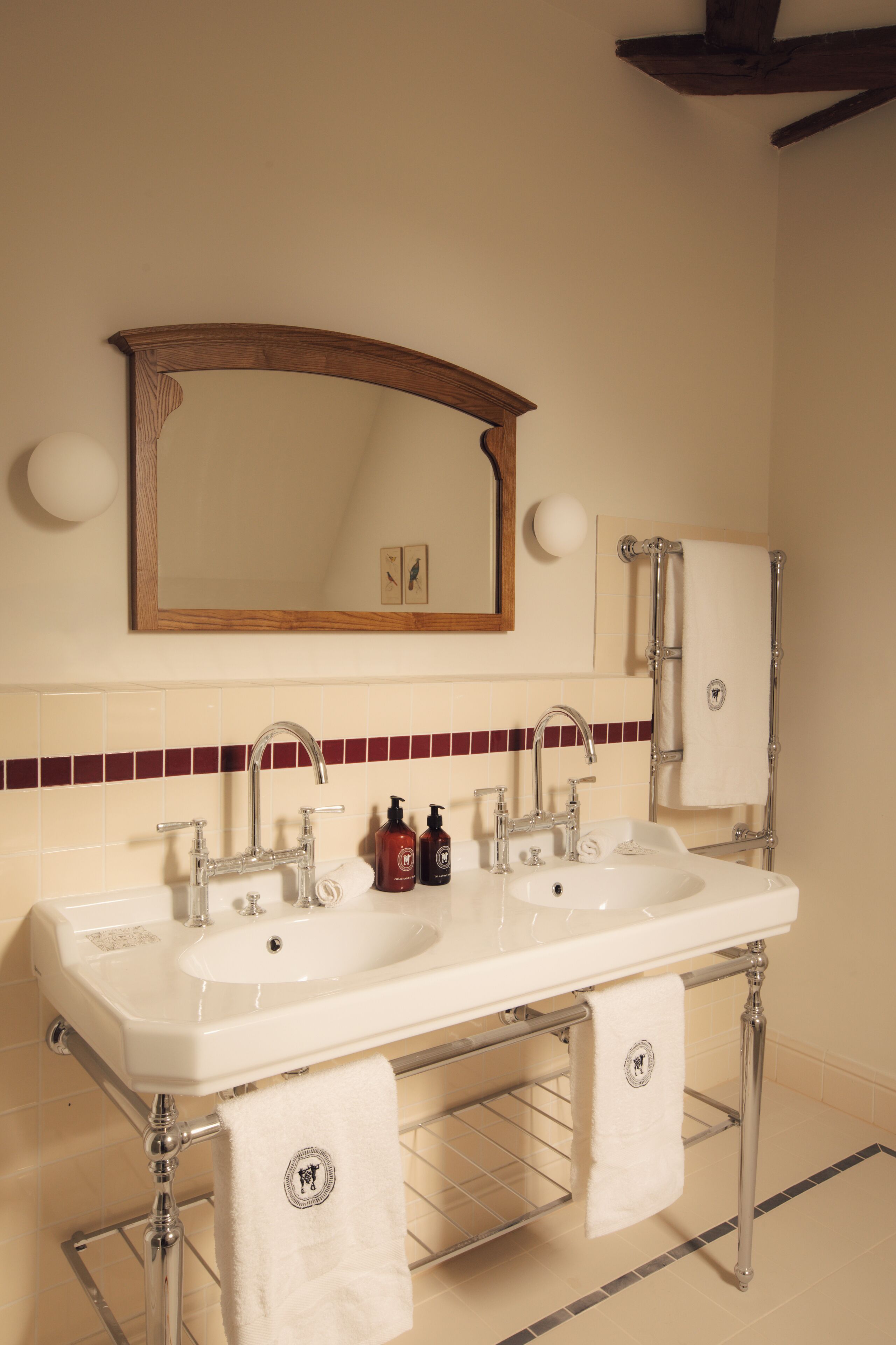 A bathroom with two sinks, a large mirror, and a towel rack.
