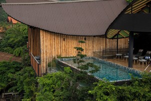 Una piscina al aire libre, sillones reclinables de piscina