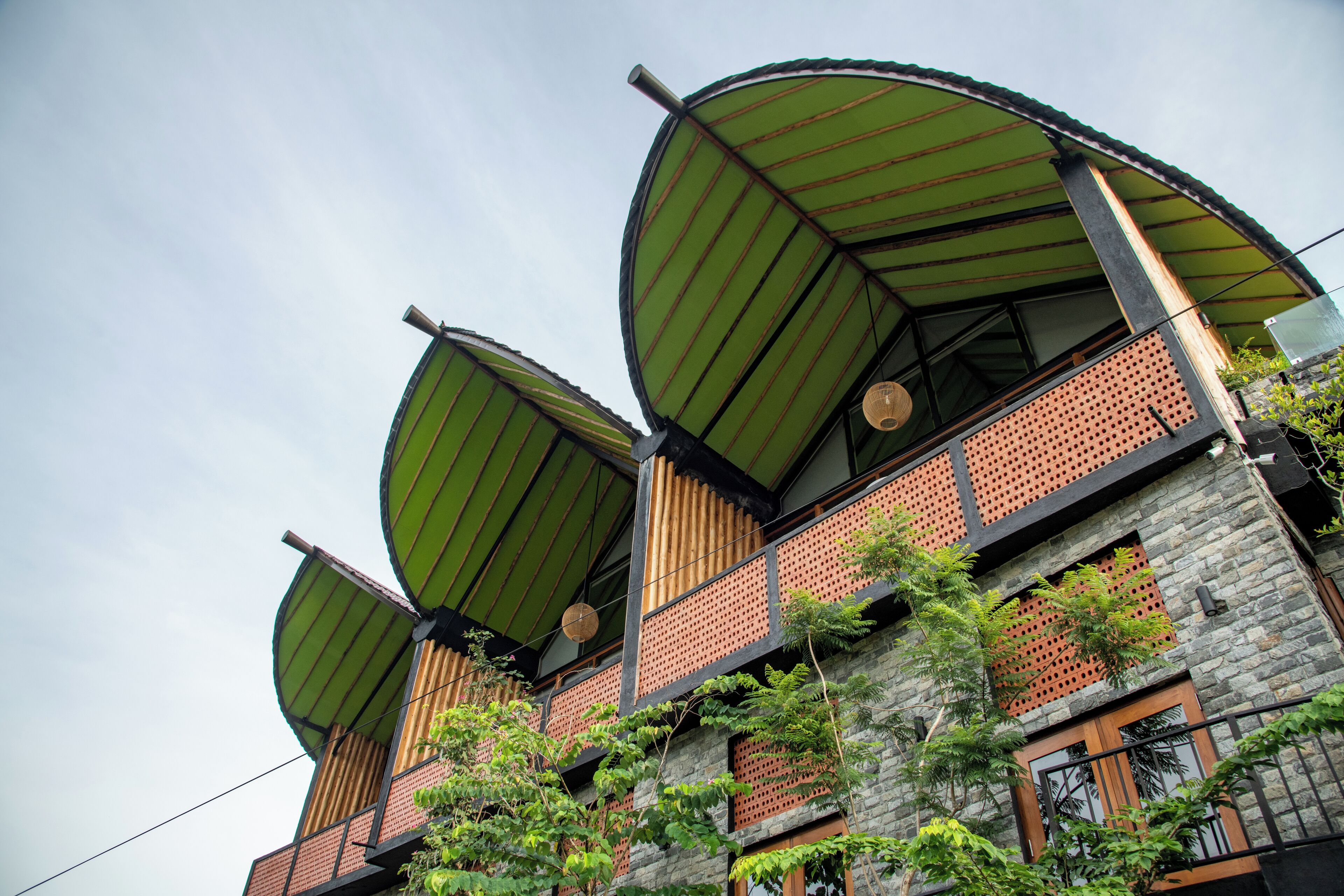 A multi-story building with curved green roofs and stone walls.