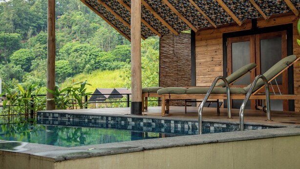 A pool area with lounge chairs and a wooden deck overlooking a lush forest. - O2 Villas Ella (Ella)