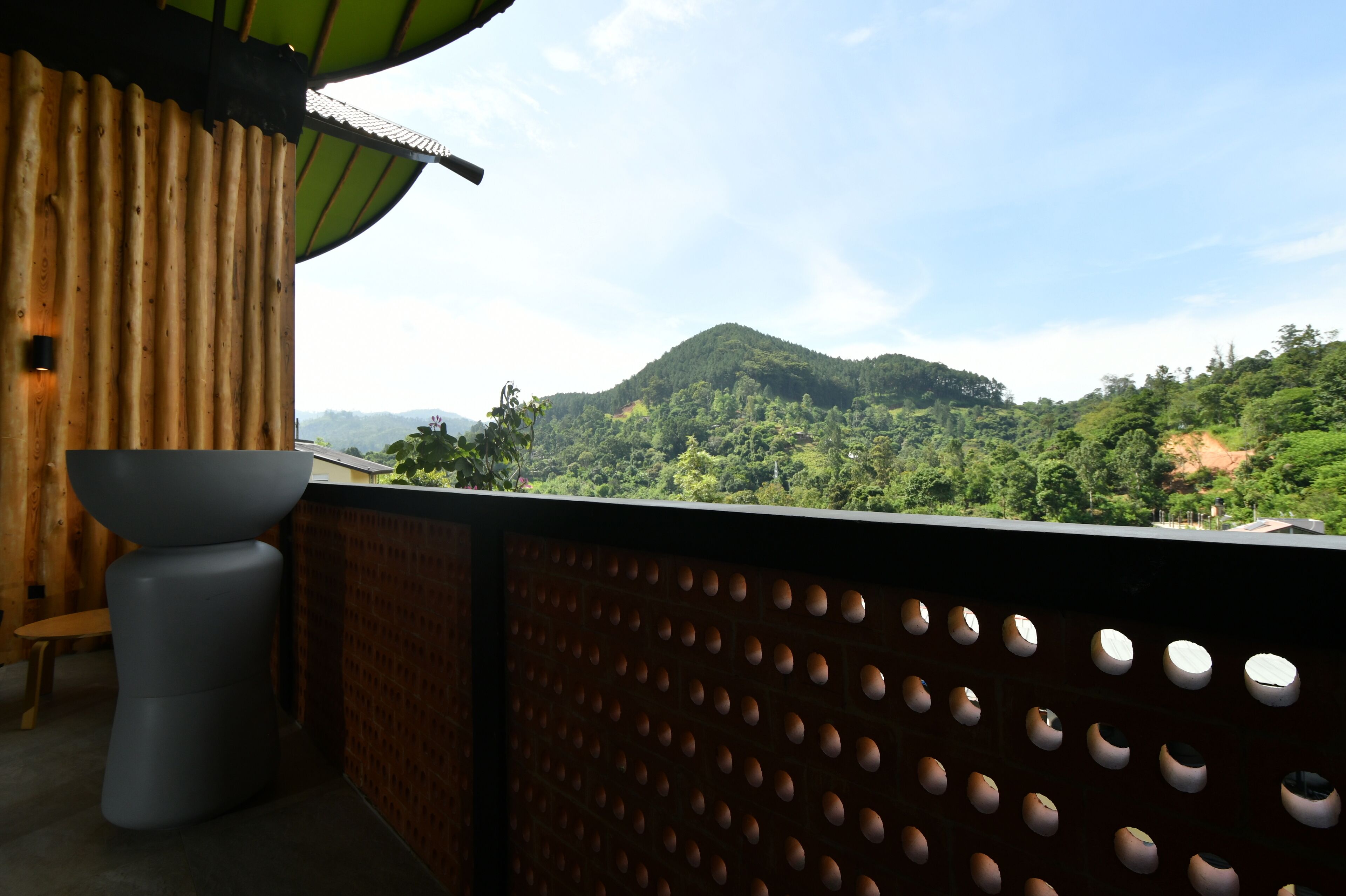 A balcony with a view of a forested mountain.