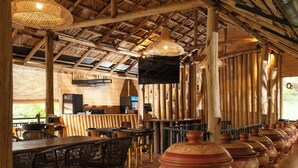 A restaurant with wooden beams, wicker chairs, and a long counter with pottery. - O2 Villas Ella (Ella)