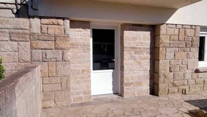 Un edificio in pietra con un portale che conduce a un balcone.