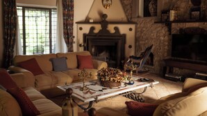 A cozy living room with a fireplace, a sofa set, and a coffee table with decorative items. - Borgo La Ferriera (Celleno)