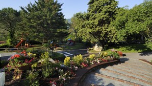 A park with a playground, a crosswalk, and a variety of flowers. - Mobile Home in Ferienresidenz mit Pool (Villanova d'Albenga)
