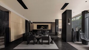 A modern living room with a dark wood floor, a central seating area with a coffee table, and a large window providing natural light. - YINGMAN HOTEL (Guilin)