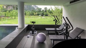A gym area with exercise equipment, a yoga mat, and a large exercise ball. - YINGMAN HOTEL (Guilin)