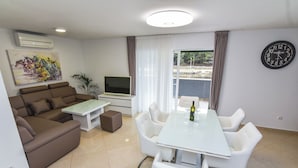 A modern living room with a sofa, TV, and dining table.